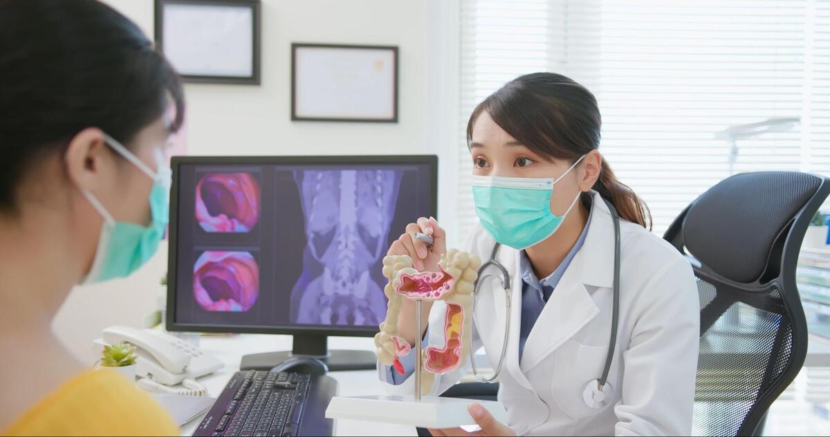 模型を使用して大腸内視鏡検査の流れと注意点の説明をしている様子