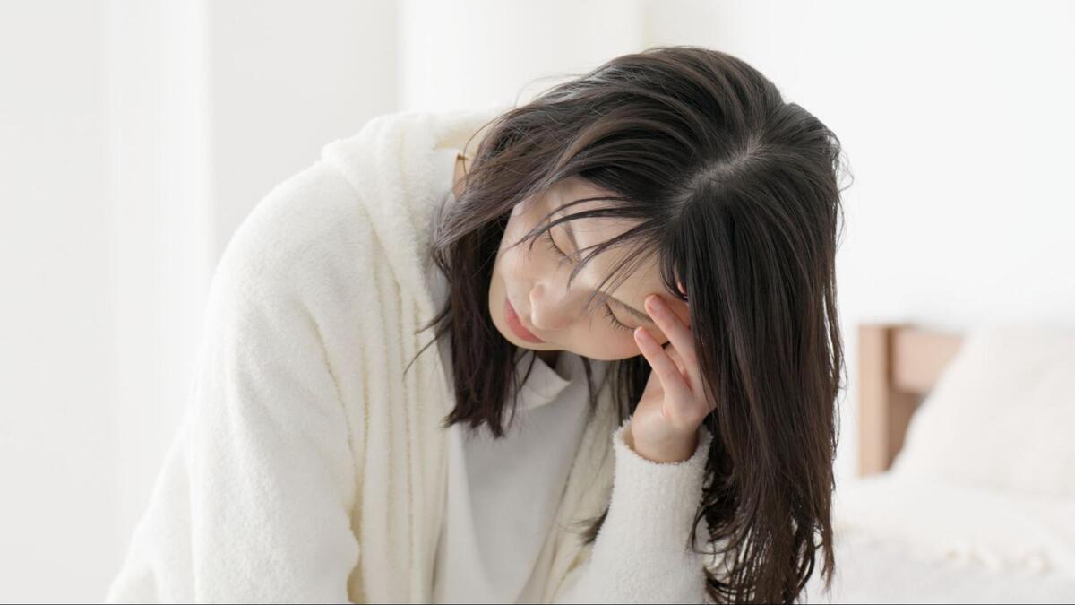頭を抱えて悩んでいる様子の女性