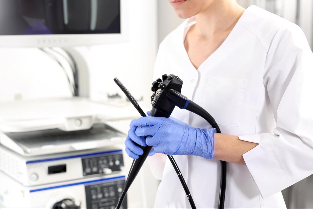 医師が大腸内視鏡検査に使用する機器を持っている